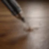 A close-up of a wax pen applied on a hardwood floor surface.